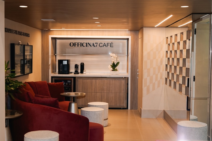 Área de espera da loja com poltronas em veludo e cafeteria